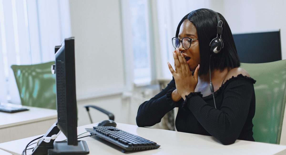 African woman sitting in computer science class. Lady with glasses. Female student sitting at the computer.
